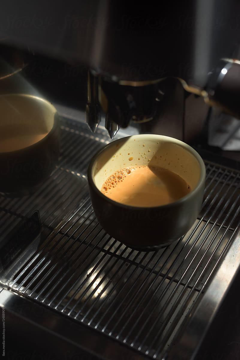 Coffee pouring into a cup from professional espresso machine