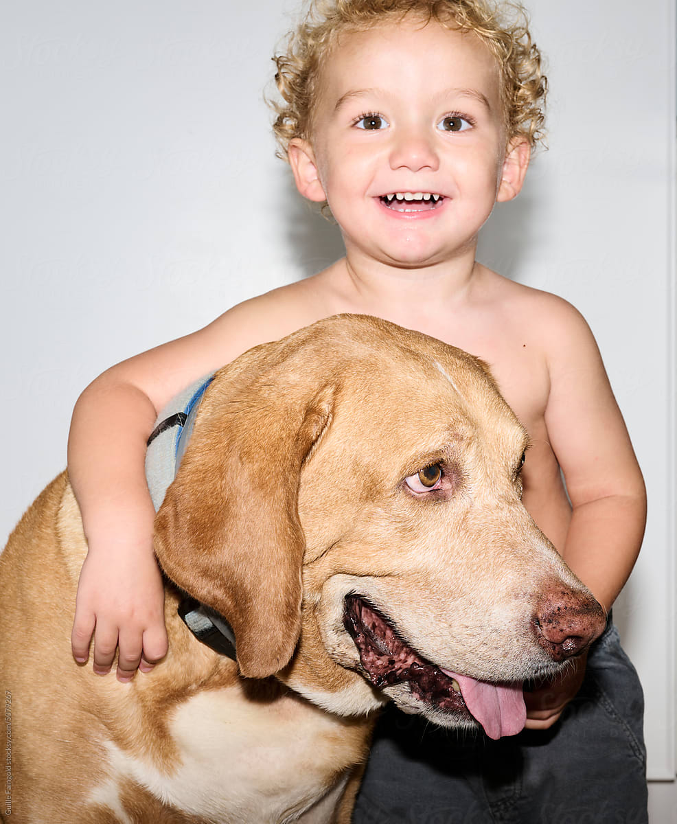 Smiling toddler with dog.