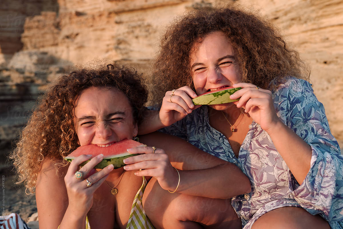 Twin sisters eating watermelon