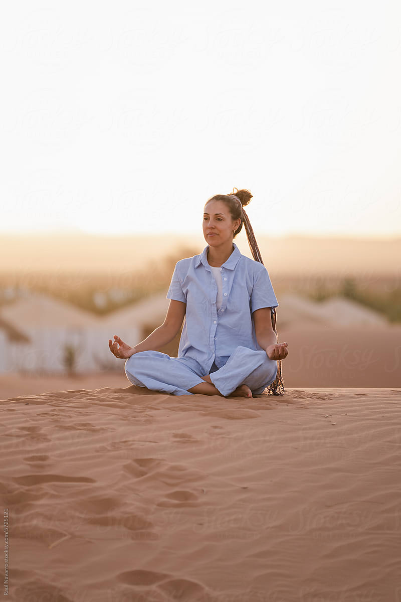 happy woman meditating in the desert