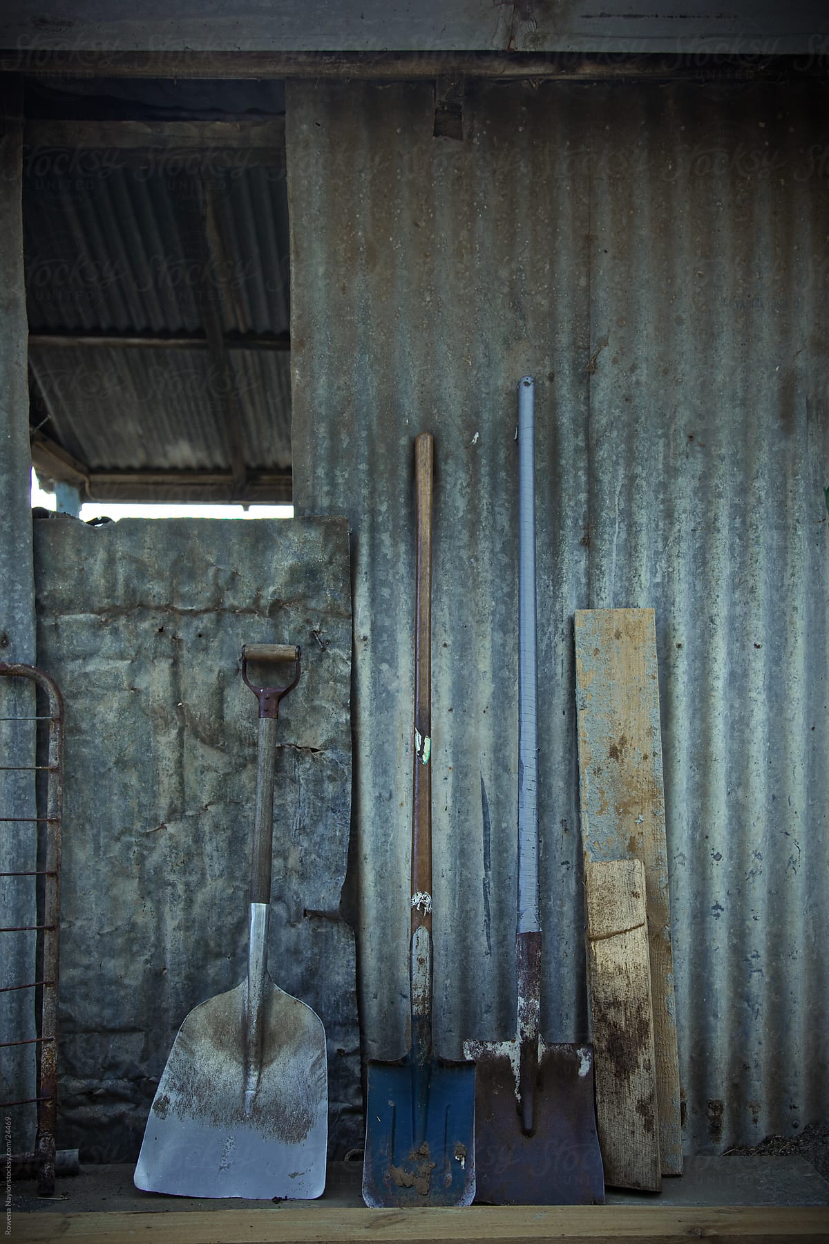 Rustic farm tools against a tin shed