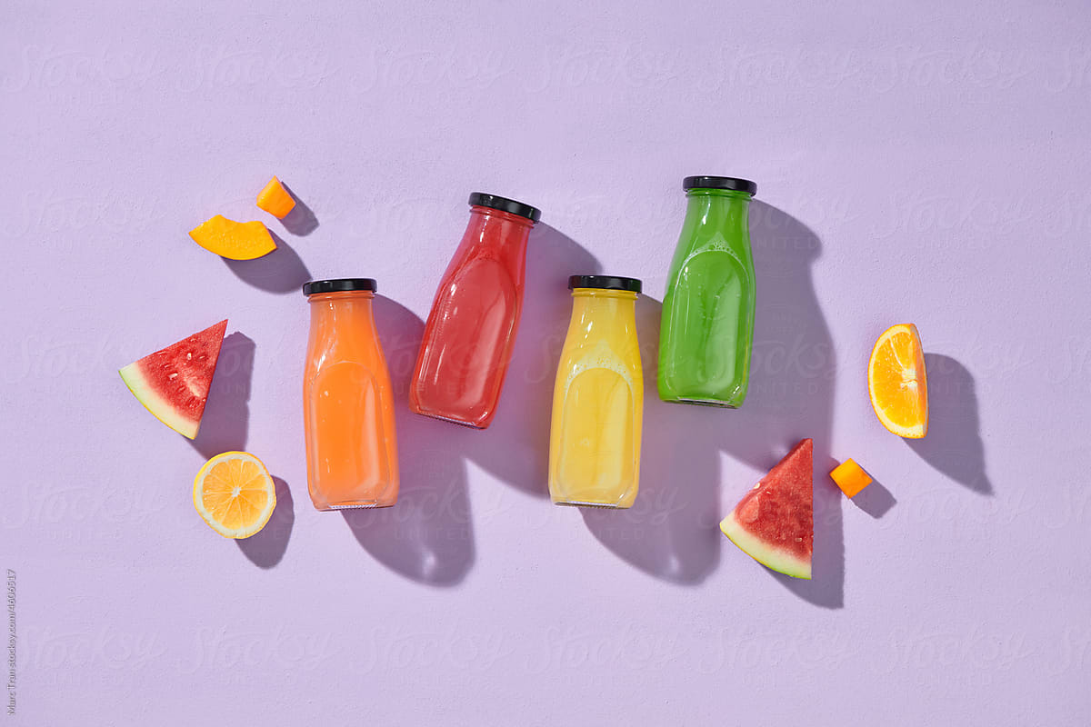 close up of glass bottles with different fruit or vegetable juices