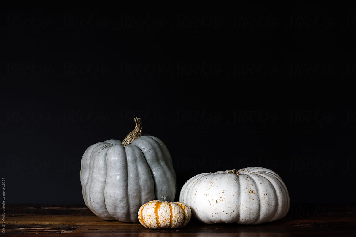 Three pumpkins on dark background