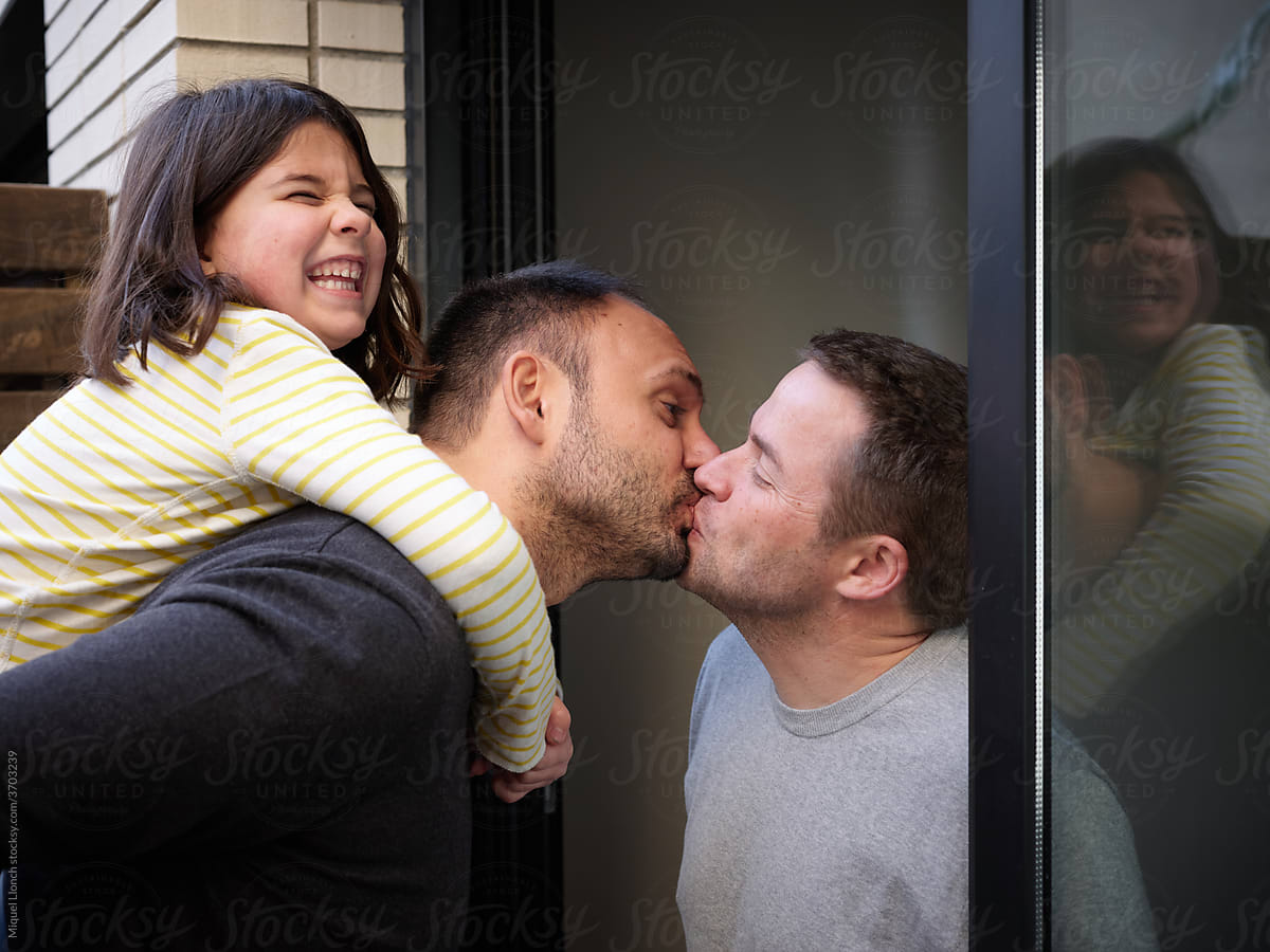 Gay couple and daughter kissing