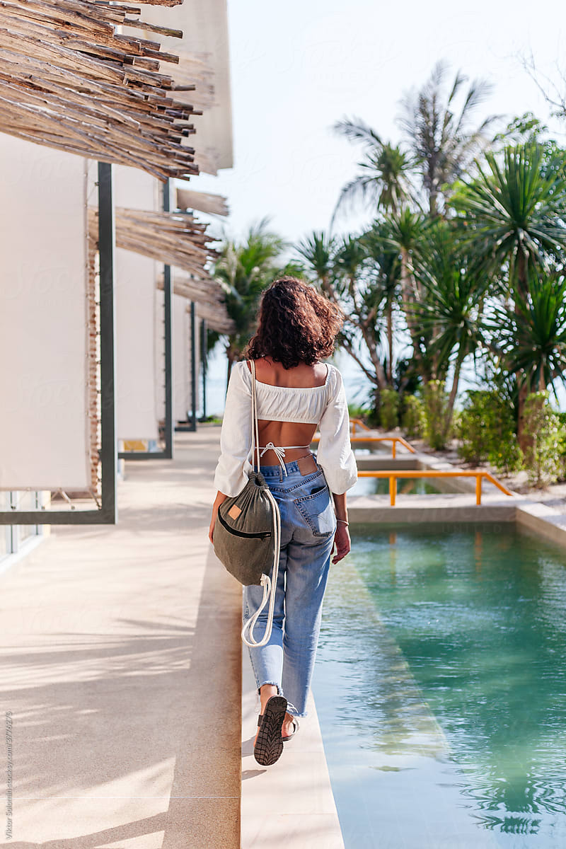 Pretty summer woman tourist style walking in luxury resort