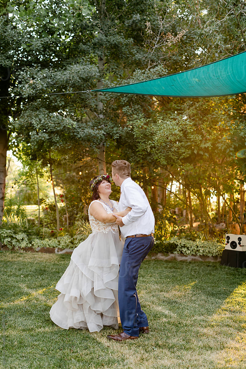 Bride and Groom Embrace on Grassy Dance Floor