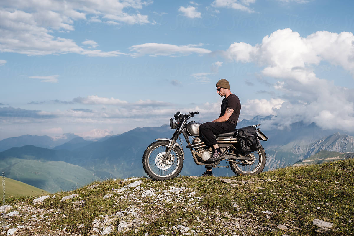 A man on top of a mountain on a motorcycle