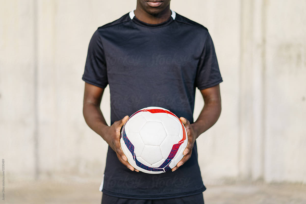 Sportsman with soccer ball looking at camera