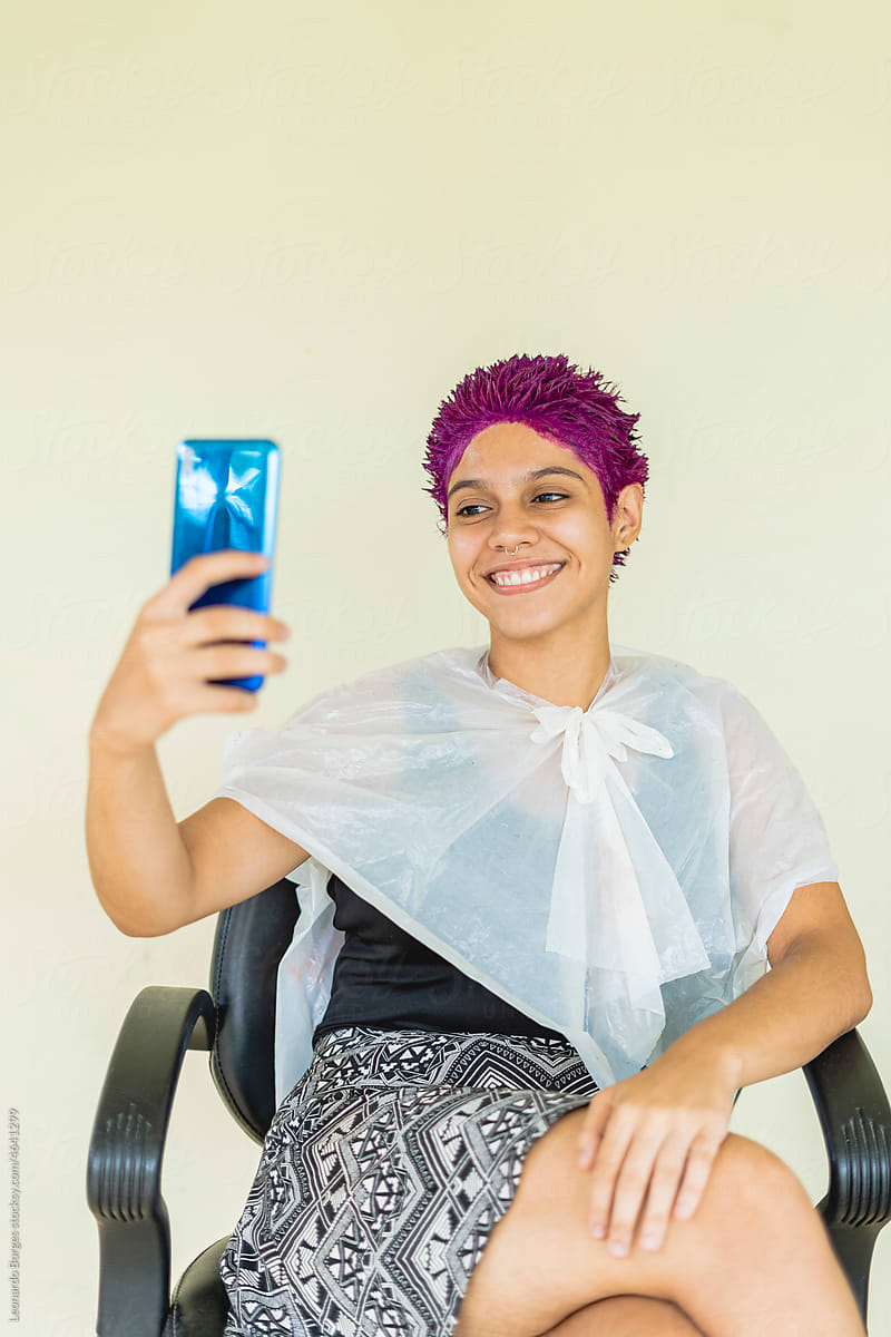 woman taking a selfie while sitting on a chair