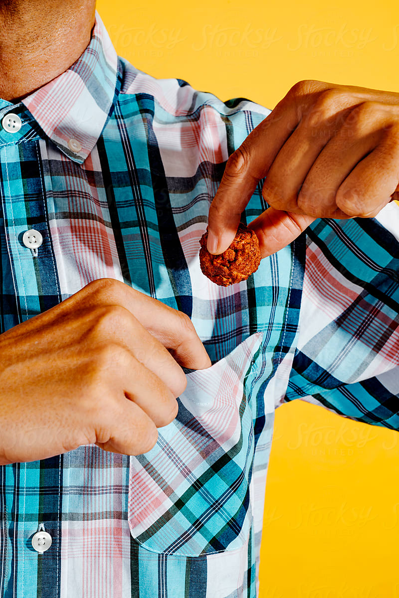 man puts a veggie meatball in his pocket