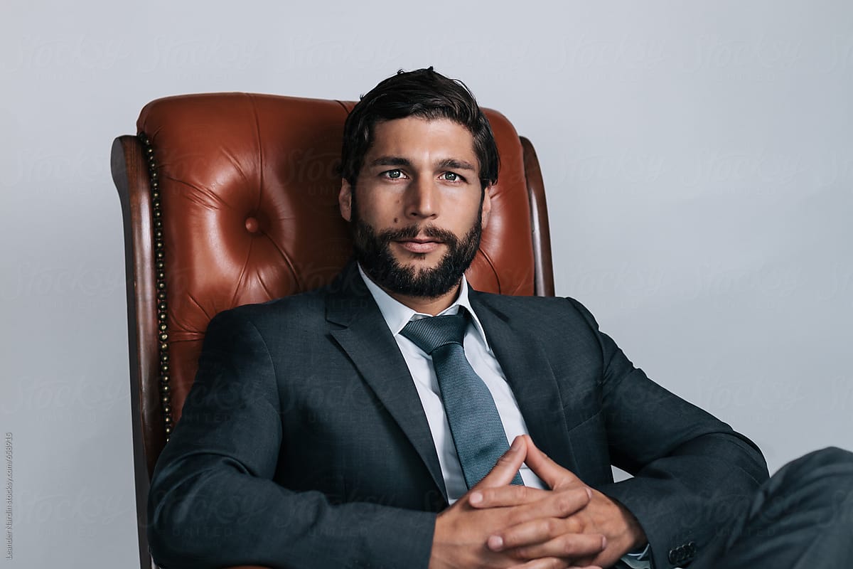 full bearded well dressed young businessman sitting in a rocking chair