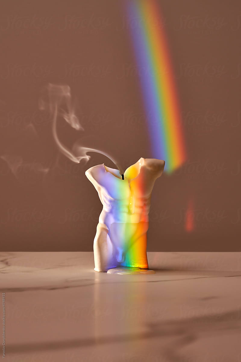 Extinguished candle with rainbow reflection.