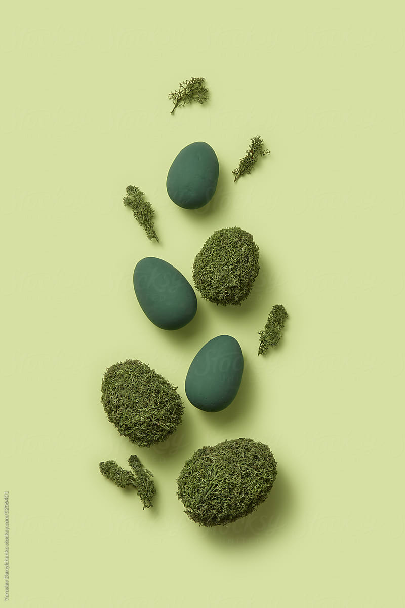 Composition of green moss and wooden Easter eggs.