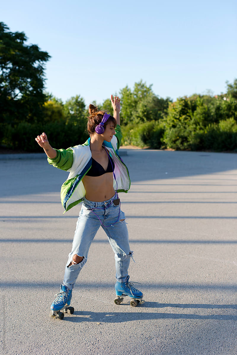 Girl in roller skates spinning outdoors in sunlight