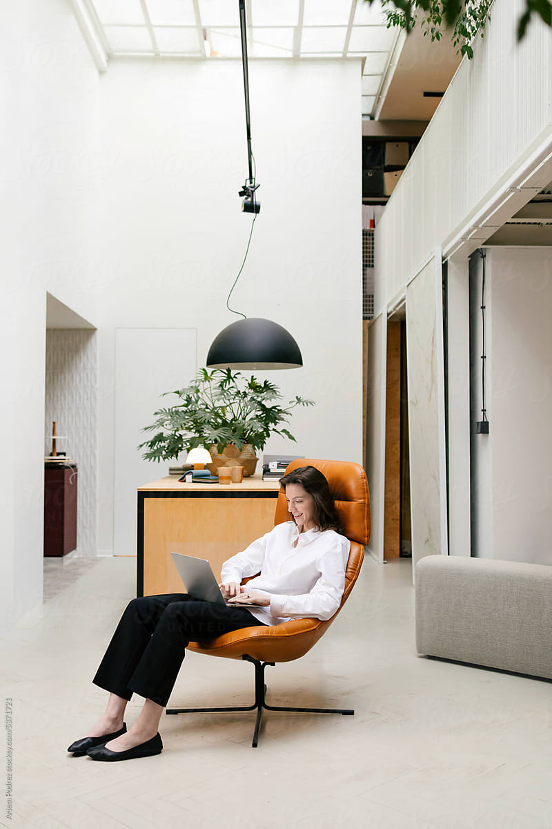 Businesswoman using laptop in designer chair