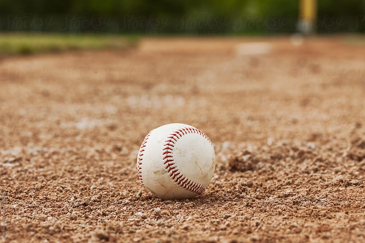 Baseball Sits In The Dirt Near First Base