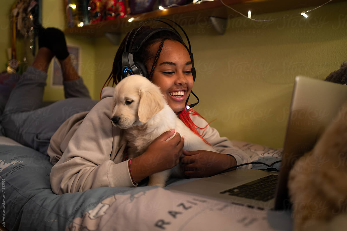 Happy Child With Laptop And Little Dog In Her Bedroom.