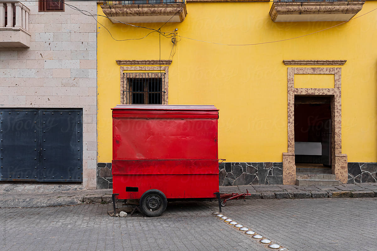 Small red food cart parked on an empty street