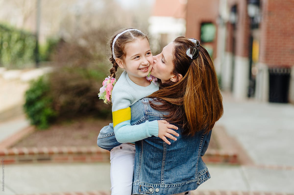 Mother Hugging And Kissing Her Young Daughter By Stocksy Contributor 