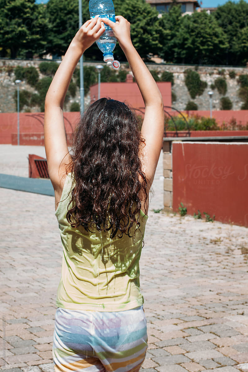 Girl Pouring Water Onto Her Head In The Summer Heat By Stocksy