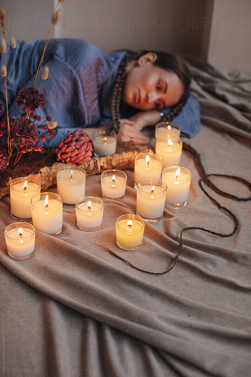 Blurred Woman laying near candles in focus