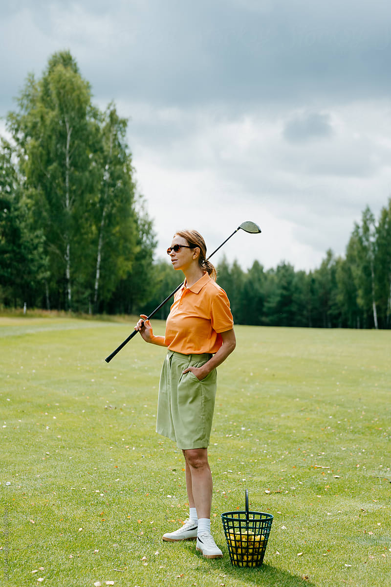 A woman with golf equipment on the course