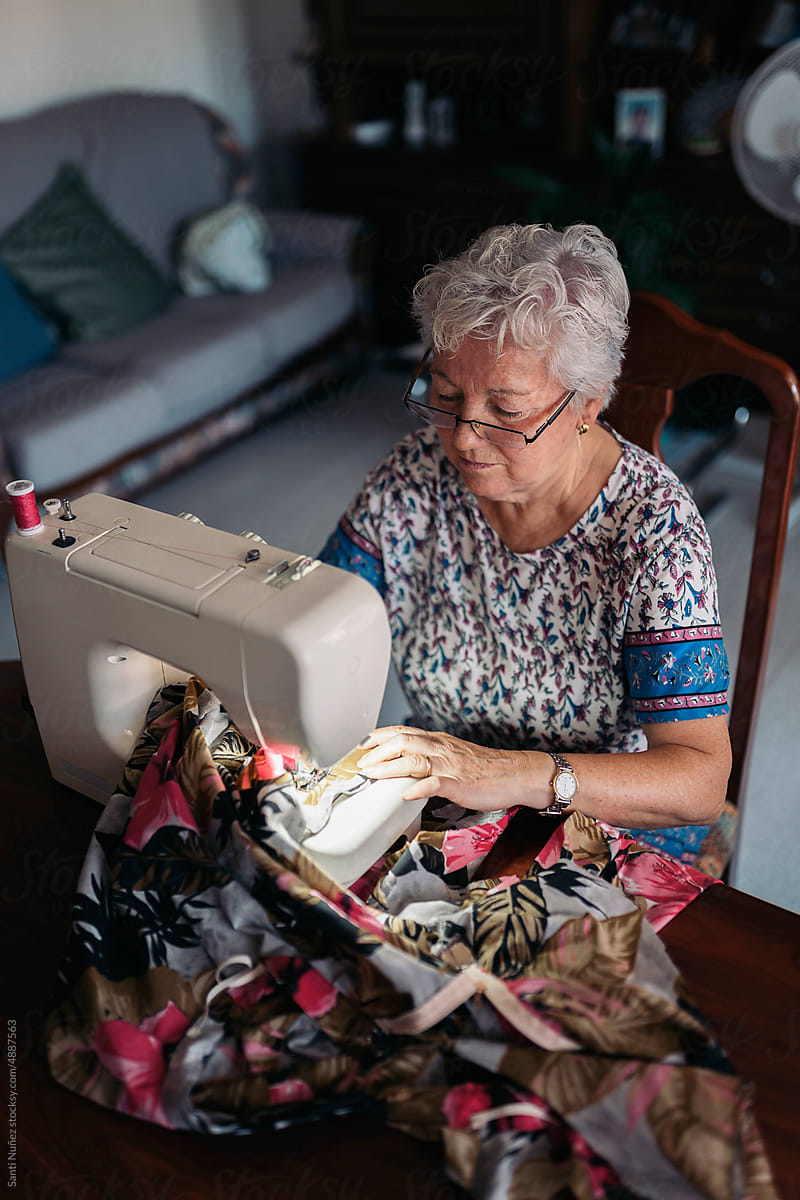 Senior seamstress sewing on machine