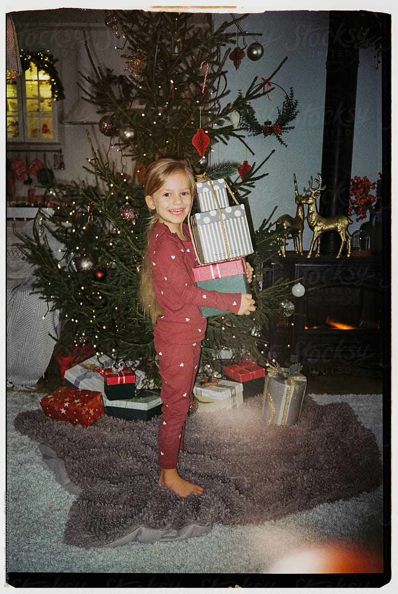 Child with stack of Christmas gifts, ugc