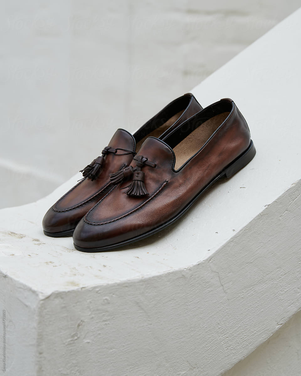 Brown stylish men\'s shoes on light concrete