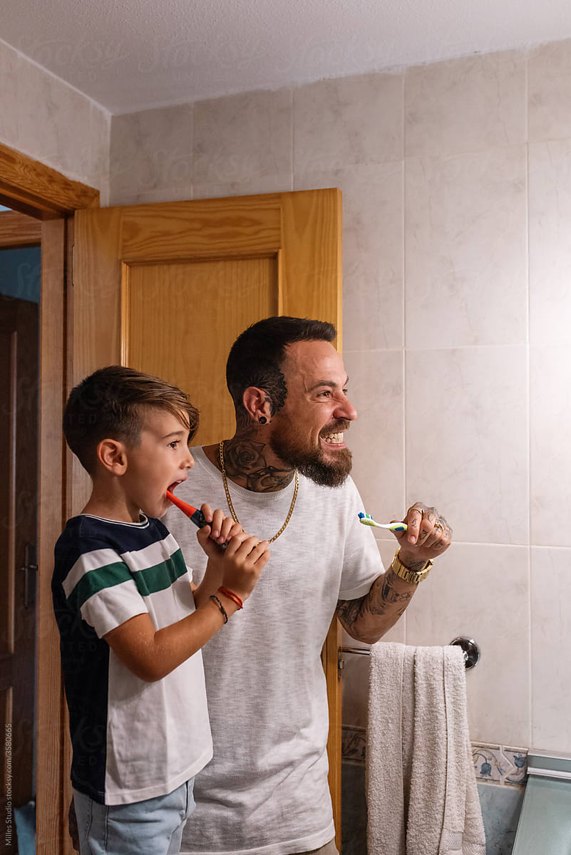 Man and boy brushing teeth