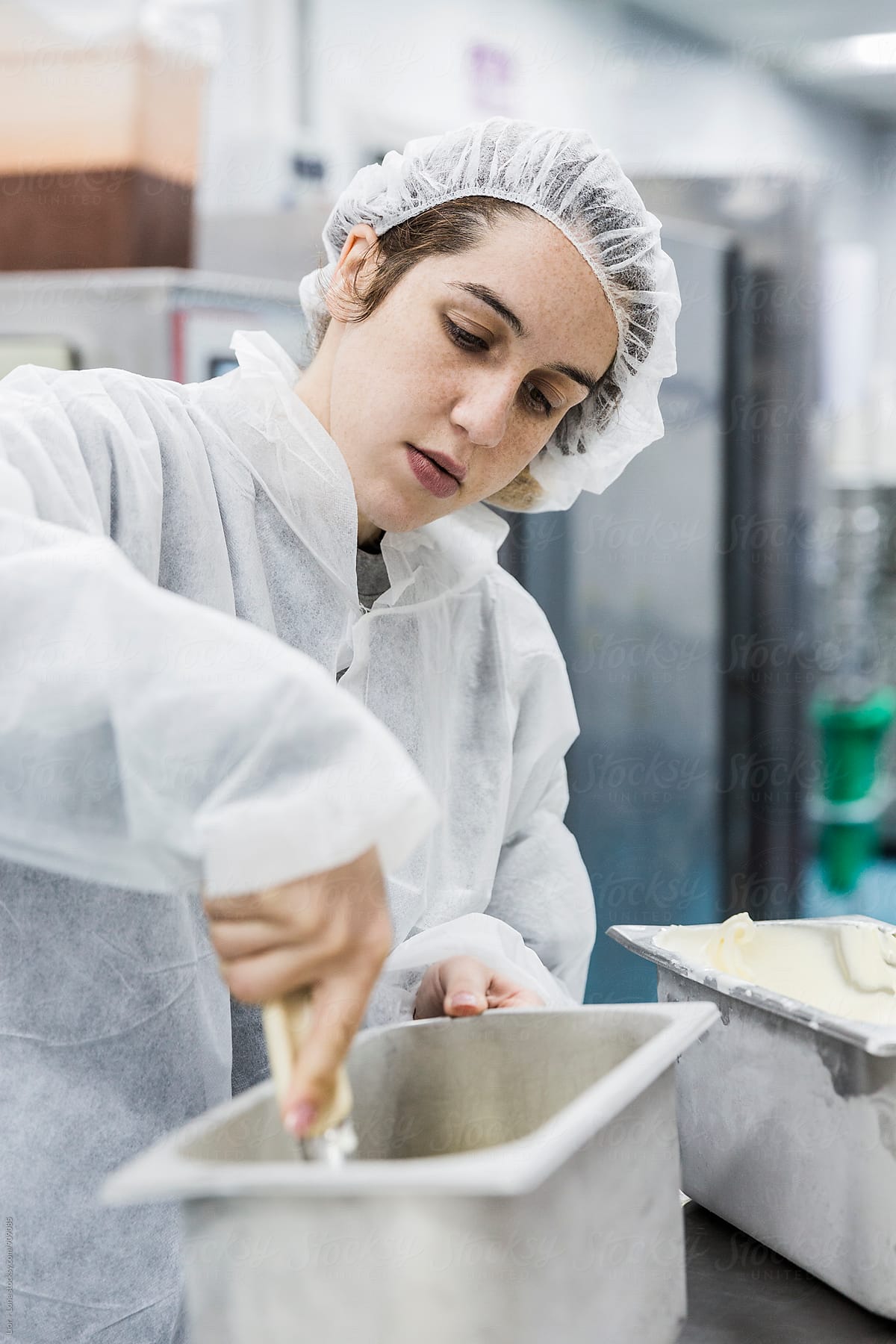 Woman with sterile clothing working in ice cream factory