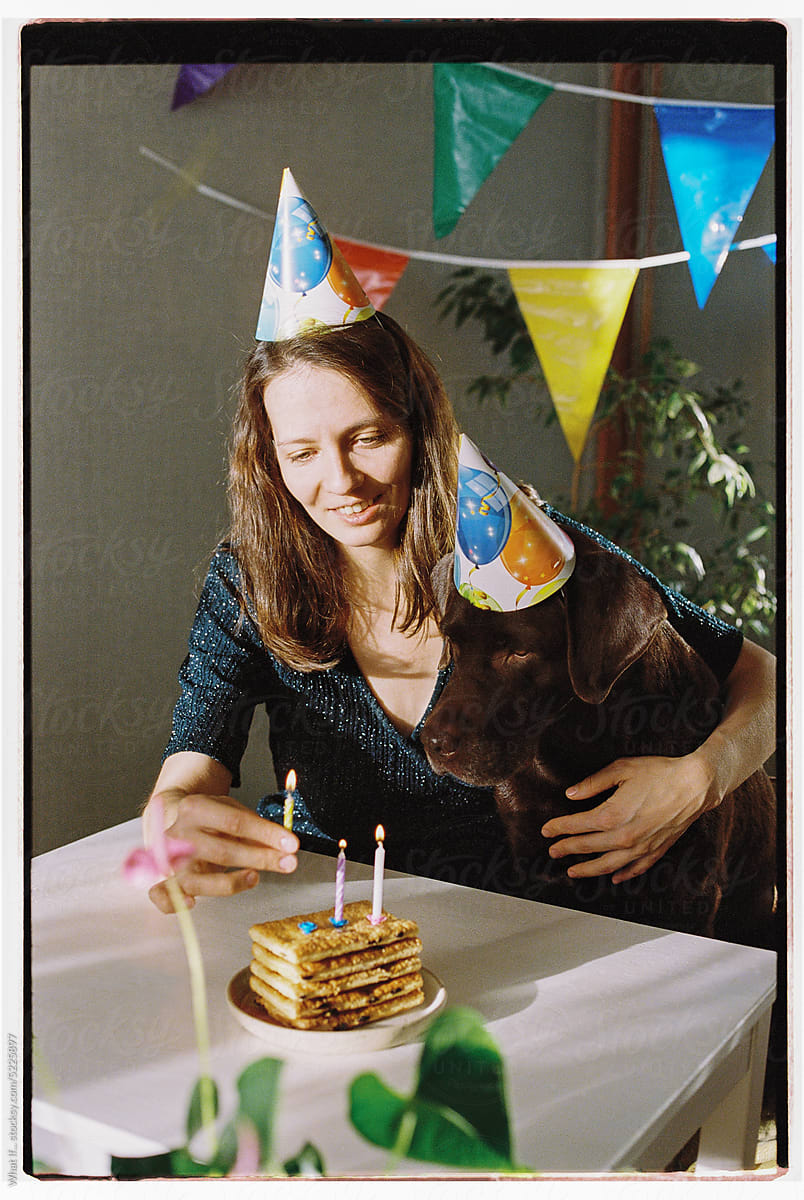 Woman and her dog are celebrating a birthday.