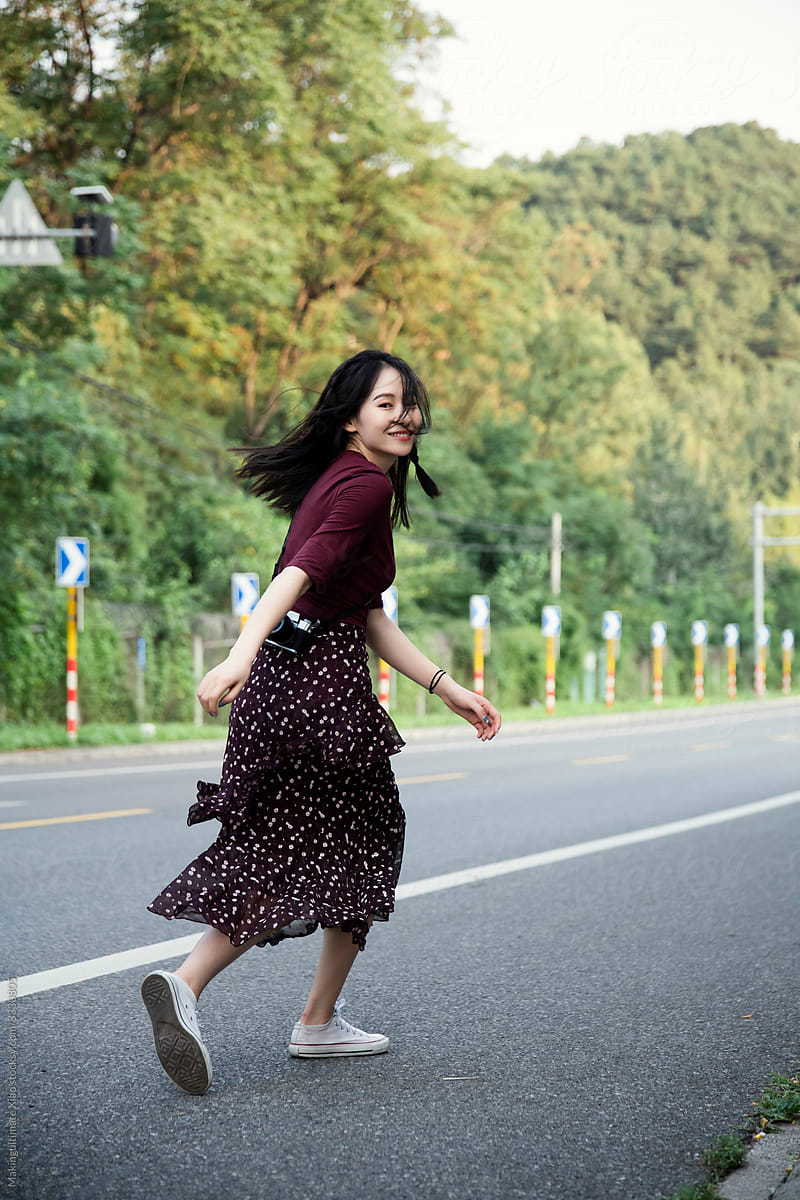 A Chinese beauty running happily on the road