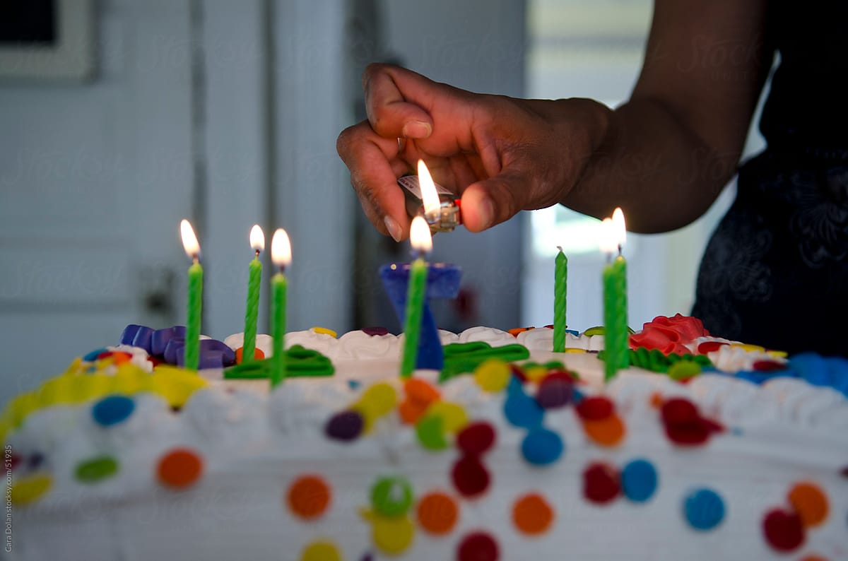 Mom lights the candles on her child\'s 7th birthday cake