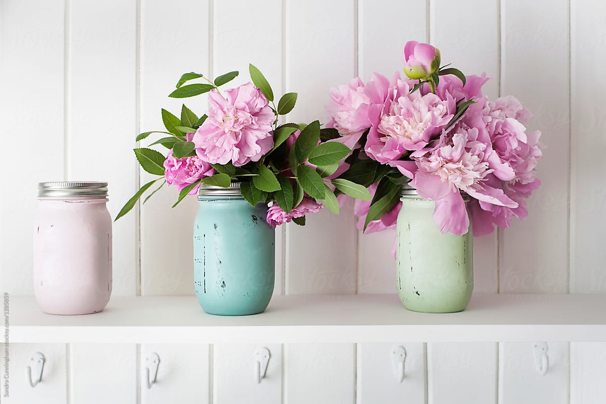 Painted jars filled with roses and peony flowers