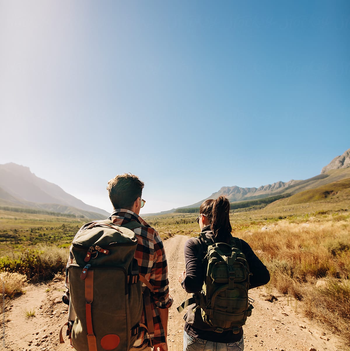 Young couple with backpack hiking on an extreme terrain