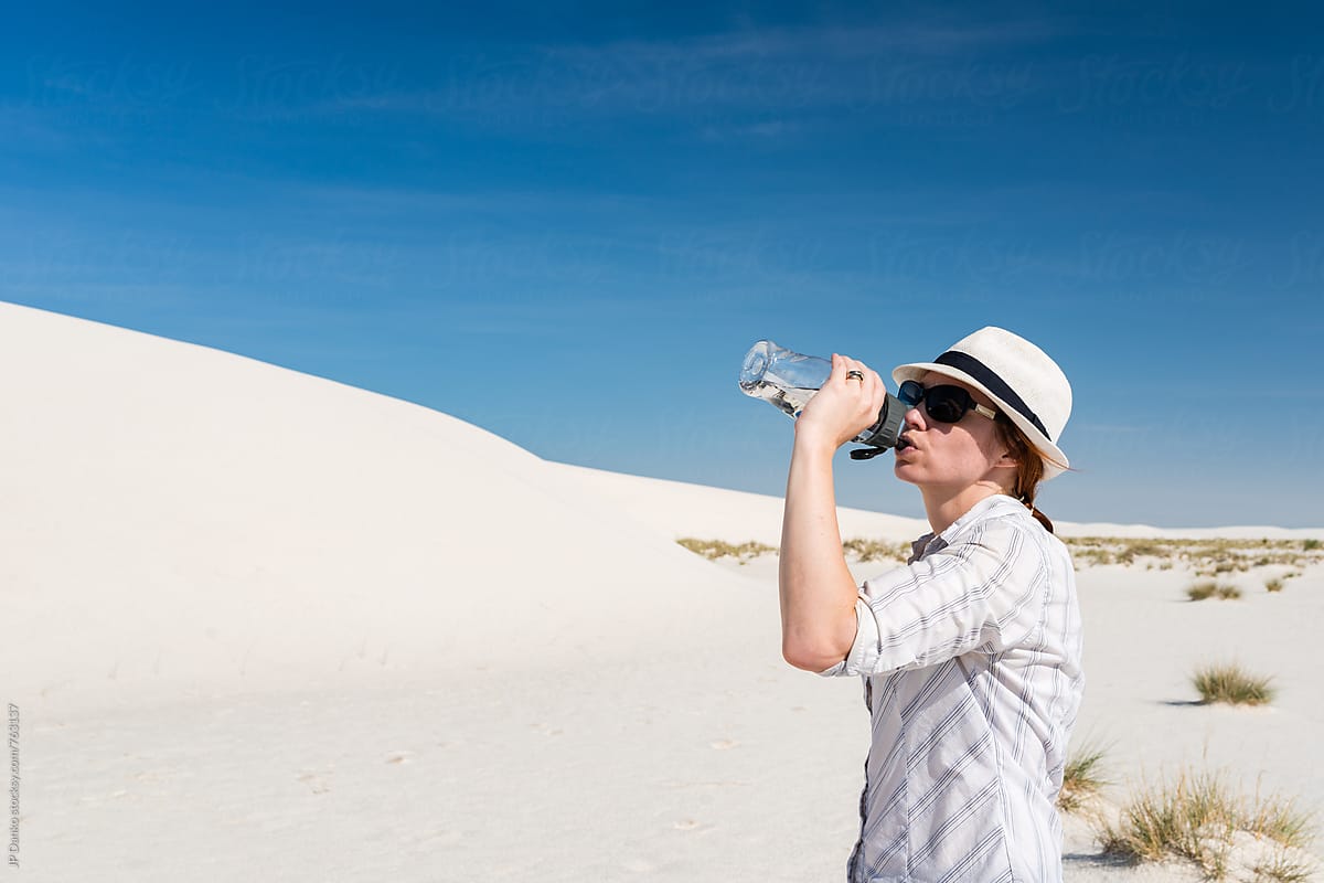 Woman Drinking from Water Bottle Sand Sledding In White Sands National Monument New Mexico