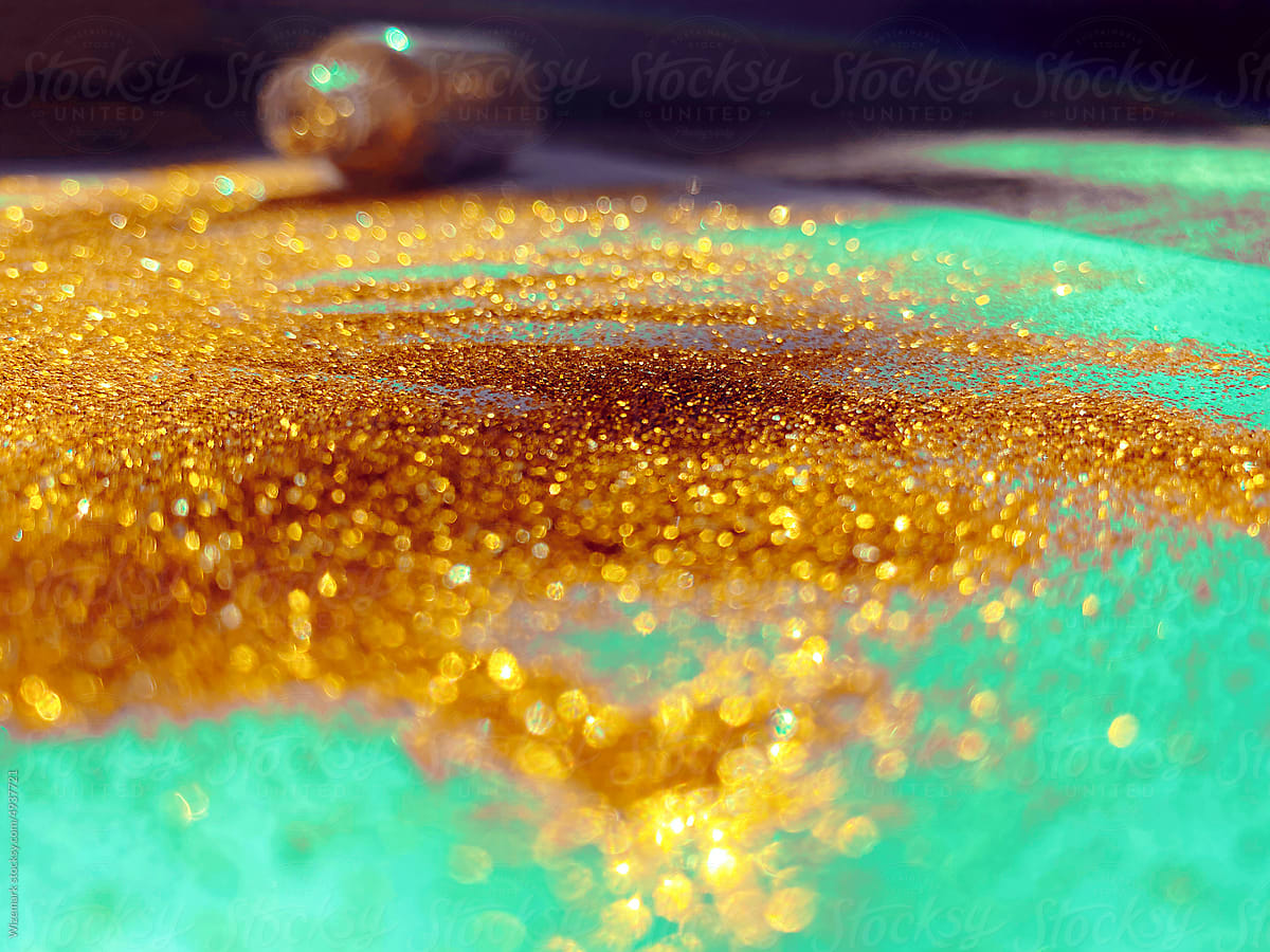 Golden glitter spilled from the plastic bottle in the background.
