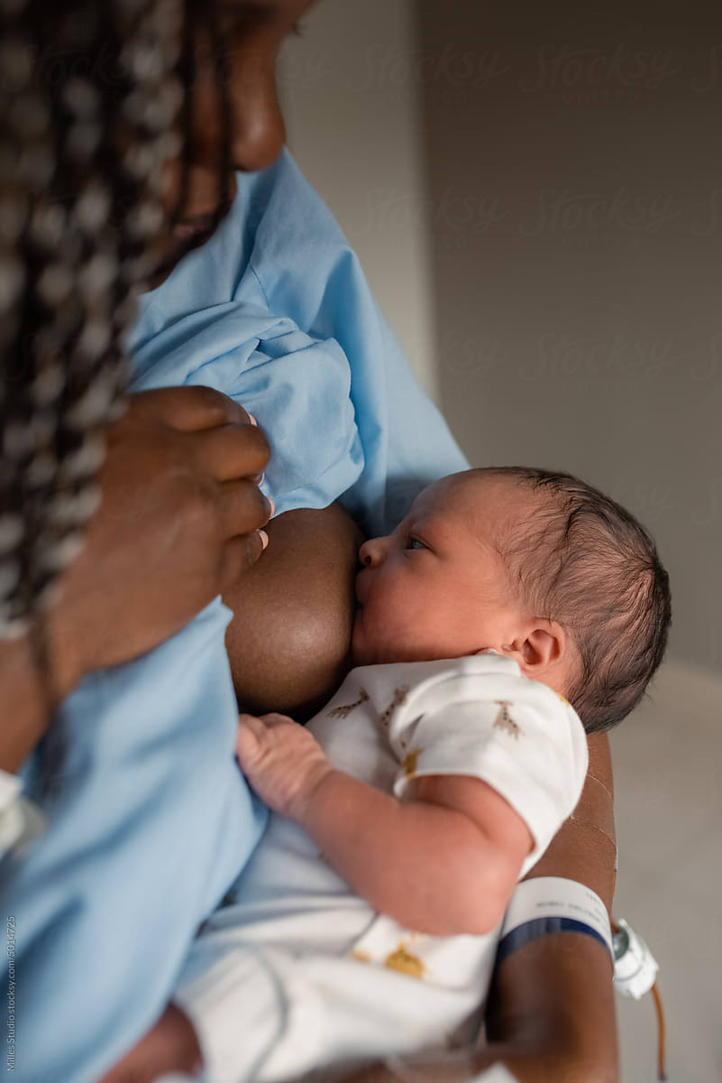 African mom breastfeeding infant in maternity hospital