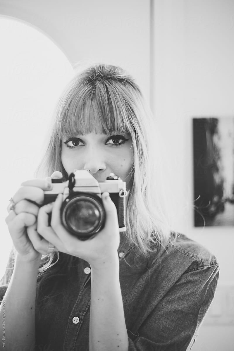 A portrait of a young woman behind a camera