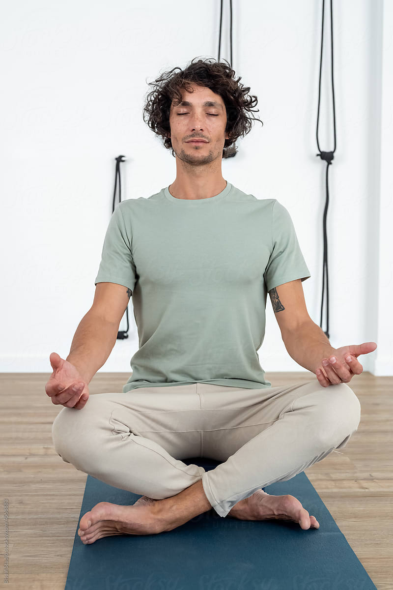 Man meditating in Lotus pose in studio