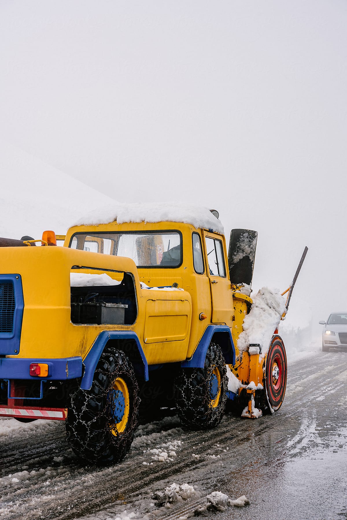 A snow plow  tractor clearing the snow on the roads from a winter storm