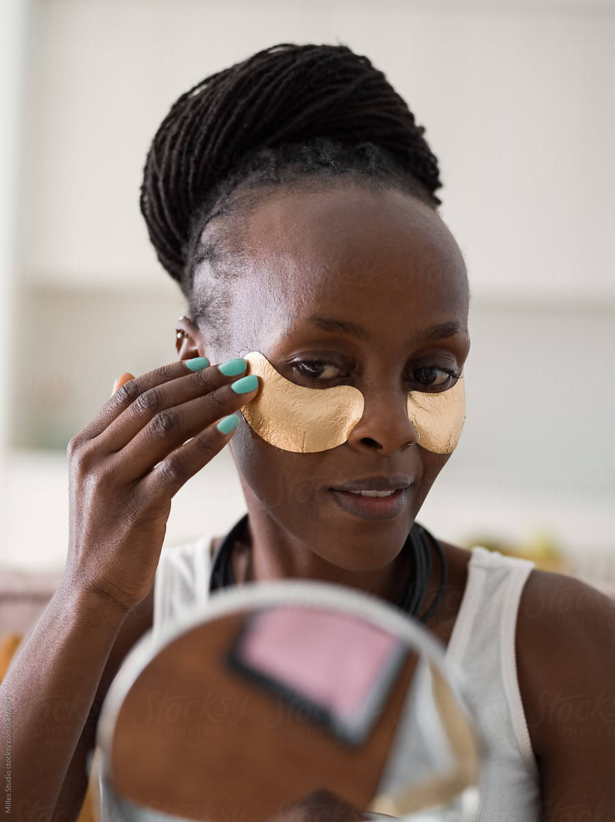 Black woman touching golden eye patch
