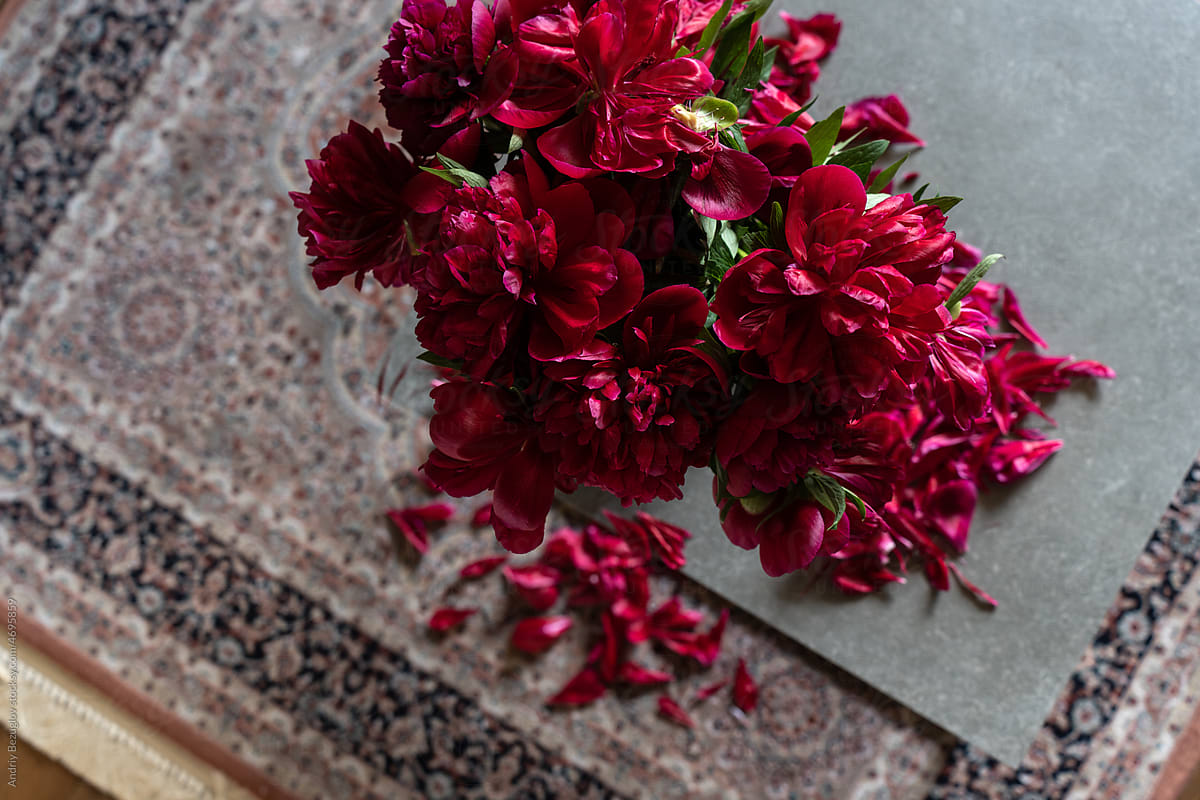 Close-up of a fading bouquet of bright red peonies.
