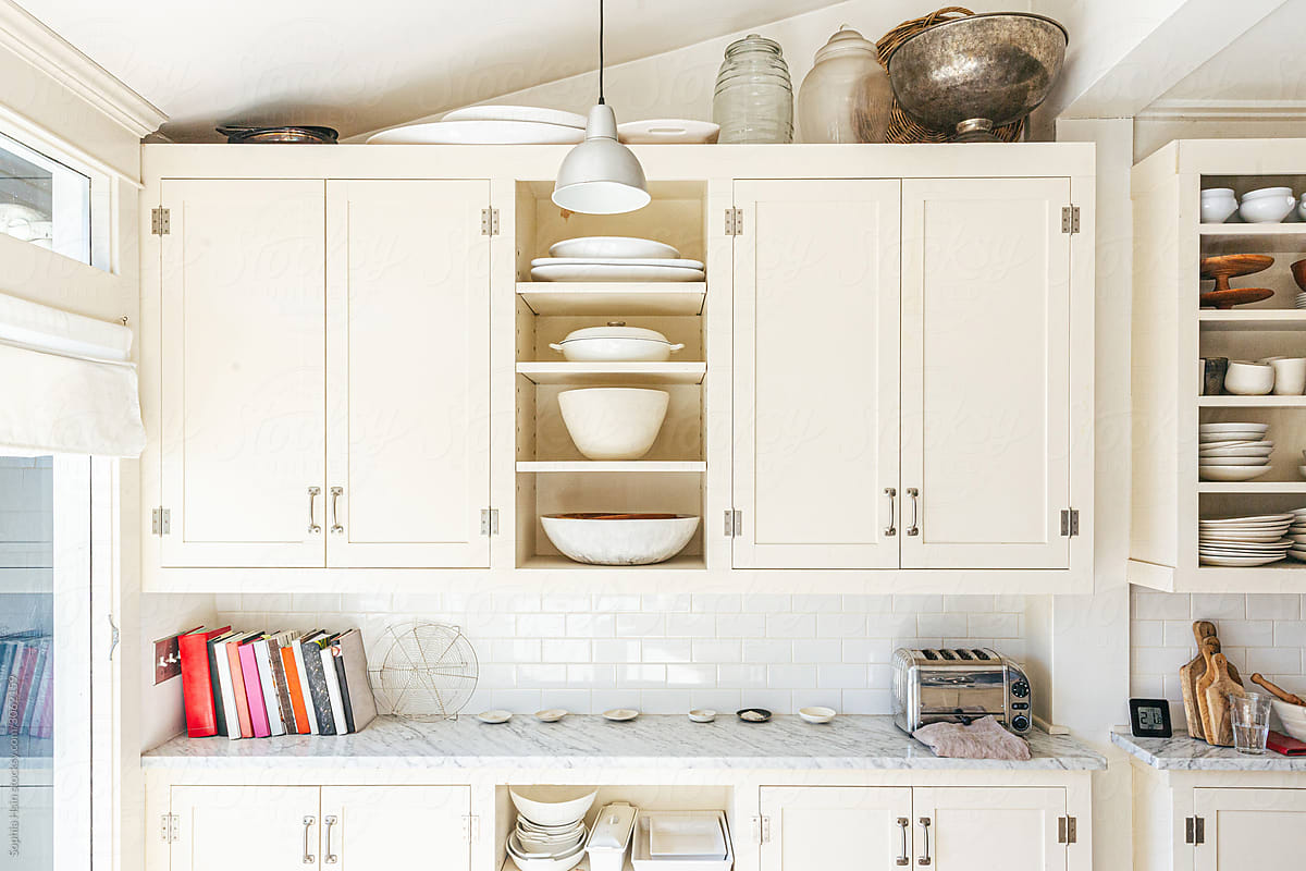 Interiors of kitchen with shelves, ceramics and books