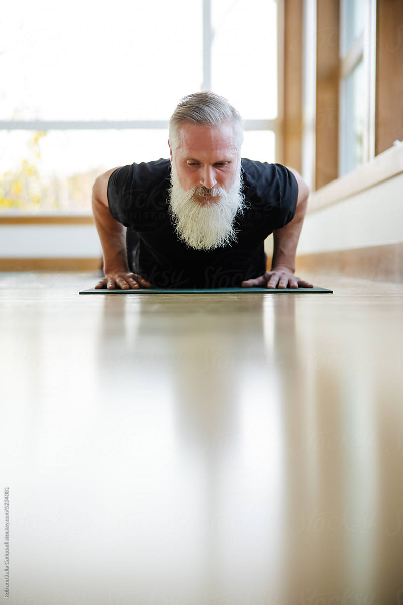 Man with white beard in yoga flow.