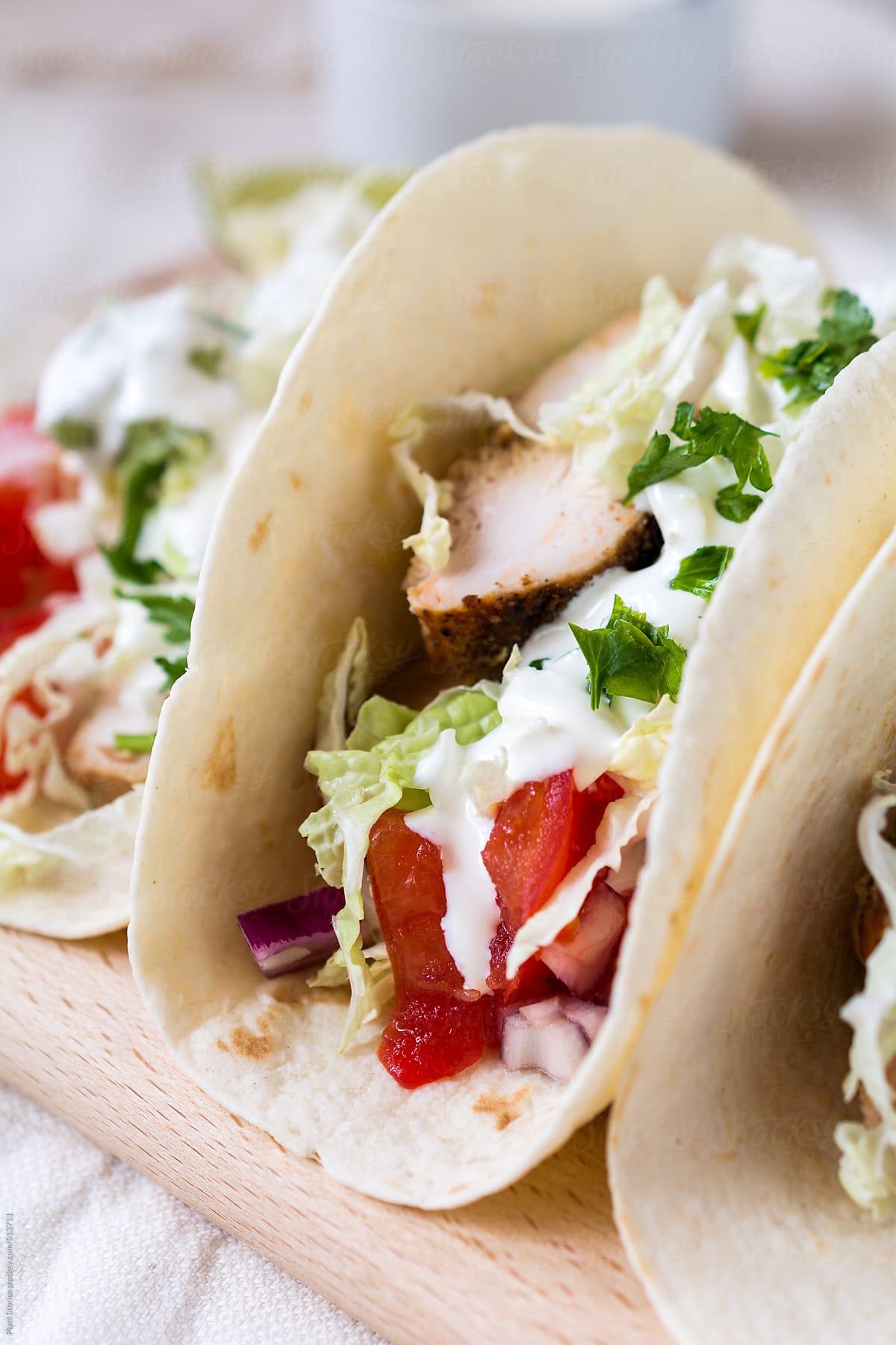 Food: close-up of tacos with roasted chicken, sour cream and vegetables