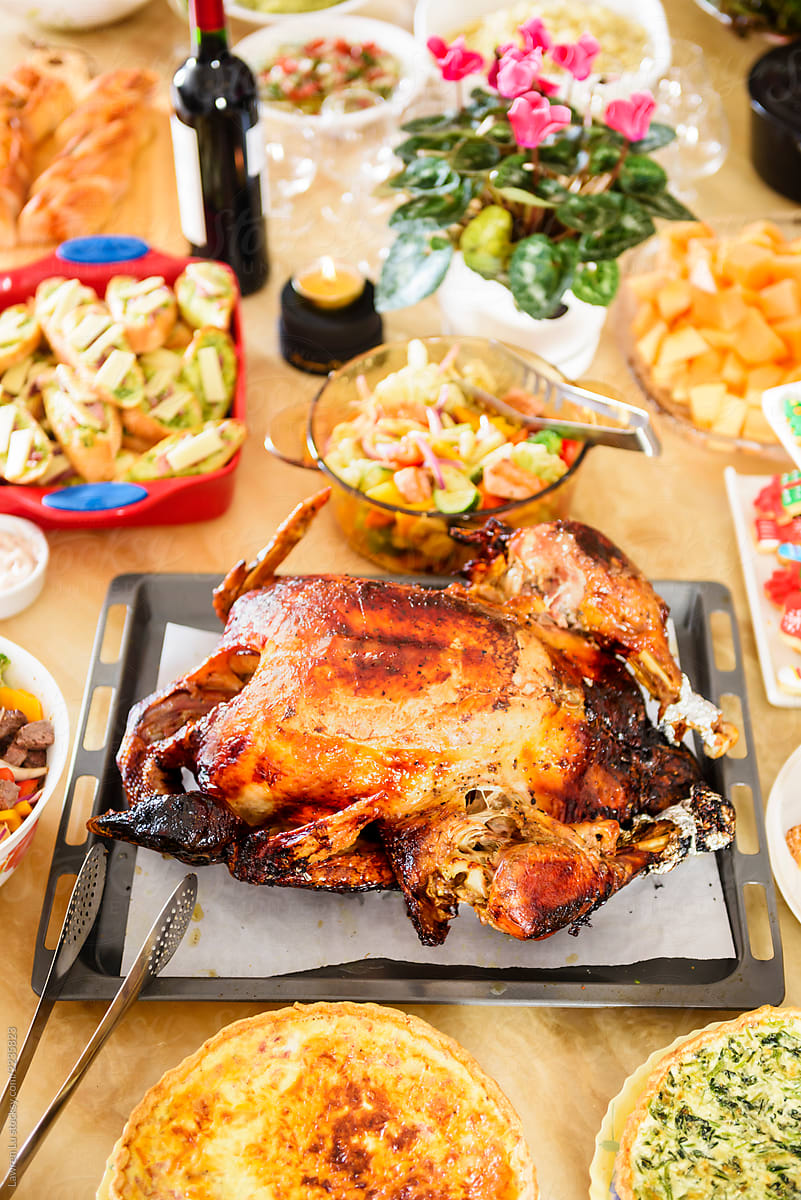 Roasted turkey on a marble table decoraded with salads, pie, bre