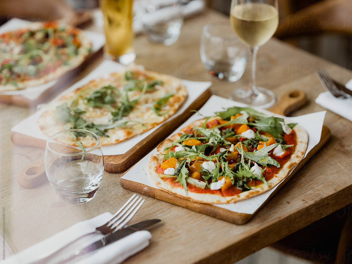 A selection of pizza on a wooden table in a pub