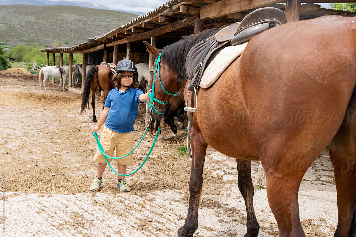 Child with his horse at stable